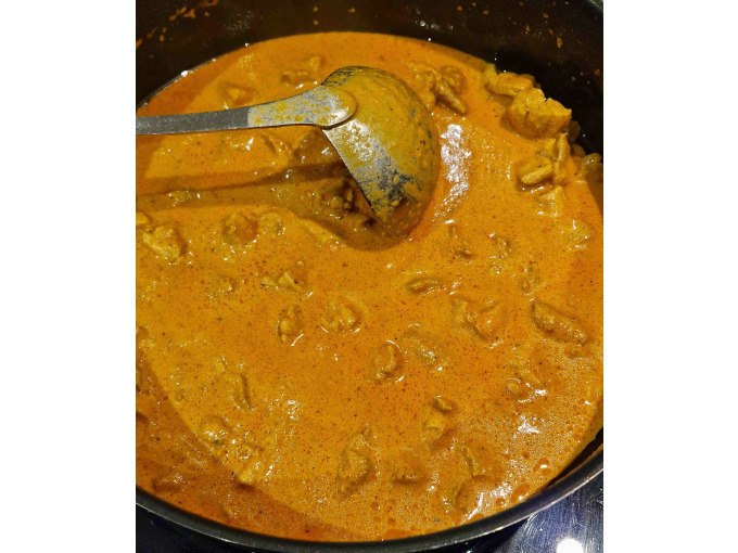 Ein Topf mit cremigem, orangefarbenem Curry und Fleischstücken. Eine Kelle liegt in der Soße, bereit zum Servieren., © Kultweine-Kochwelten-Kunstücke - Kochschule Sonja Lenz Ein Topf mit cremigem, orangefarbenem Curry und Fleischstücken. Eine Kelle liegt in der Soße, bereit zum Servieren., © Kultweine-Kochwelten-Kunstücke - Kochschule Sonja Lenz
