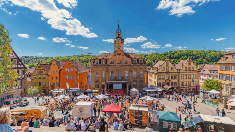 Menschen sitzen auf Treppen und genie&szlig;en den Blick auf den Marktplatz von Schw&auml;bisch Hall mit historischen Geb&auml;uden im Sonnenlicht., &copy; Michael Kuehneisen