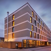 Moderne Hotelaußenfassade bei Dämmerung, beleuchtete Fenster, Schild mit 'the niu'., © Novum Hospitality Moderne Hotelaußenfassade bei Dämmerung, beleuchtete Fenster, Schild mit 'the niu'., © Novum Hospitality