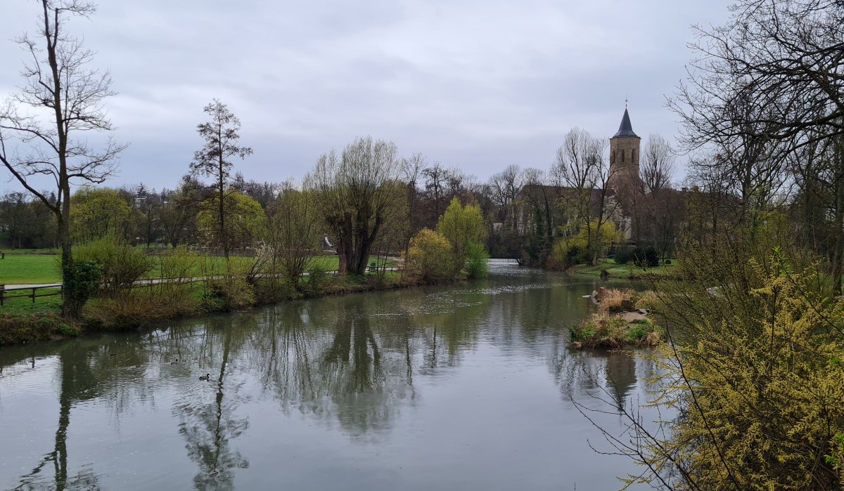 Ein ruhiger Fluss in Waiblingen, umgeben von Bäumen und Wiesen, mit einer Kirche im Hintergrund unter bewölktem Himmel., © Remstal Tourismus e.V.
