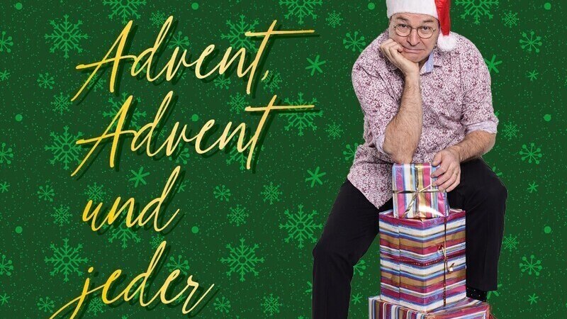 Ein Mann mit Weihnachtsm&uuml;tze sitzt auf einem Stapel Geschenke vor einem gr&uuml;nen Hintergrund mit Schneeflocken und dem Text 'Heinrich del Core - Advent, Advent und jeder rennt...'., &copy; SBEntertainment GmbH & Co. KG