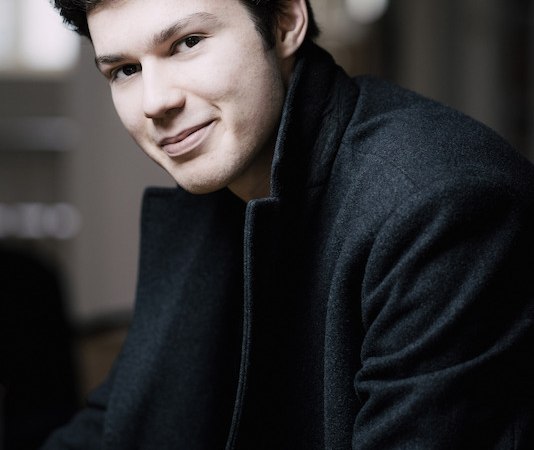 Ein junger Mann in einem dunklen Mantel lächelt in die Kamera. Der Hintergrund ist unscharf., © Stadt Böblingen - Amt für Kultur