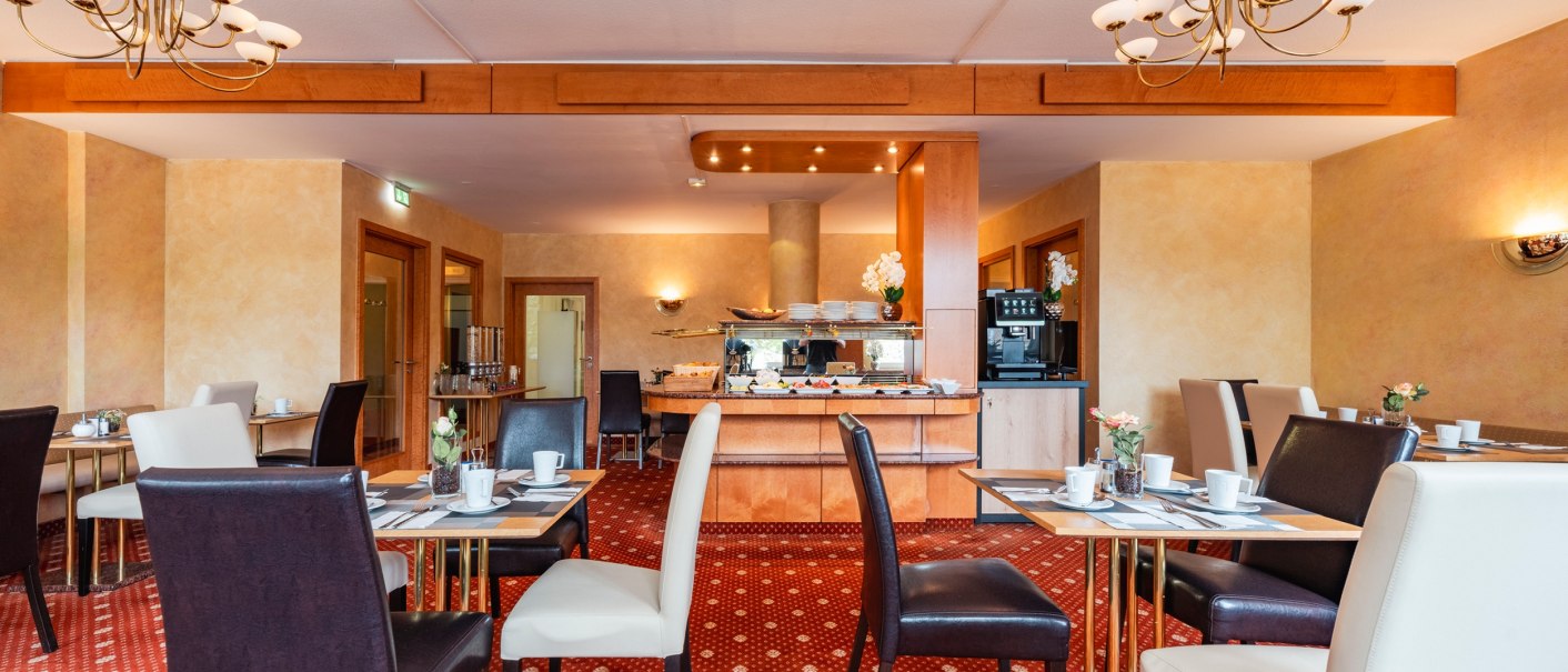 Eleganter Frühstücksraum mit gedeckten Tischen, bequemen Stühlen und einem Buffet im Hintergrund. Warme Farben und stilvolle Beleuchtung., © PLAZA INN Rieker Stuttgart Hauptbahnhof Eleganter Frühstücksraum mit gedeckten Tischen, bequemen Stühlen und einem Buffet im Hintergrund. Warme Farben und stilvolle Beleuchtung., © PLAZA INN Rieker Stuttgart Hauptbahnhof