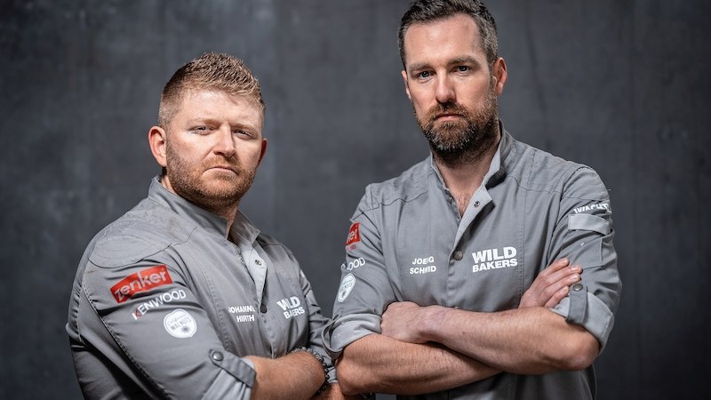 Zwei Männer in grauen Hemden mit "Wild Bakers"-Logo stehen mit verschränkten Armen vor einem grauen Hintergrund., © Stadthalle Leonberg