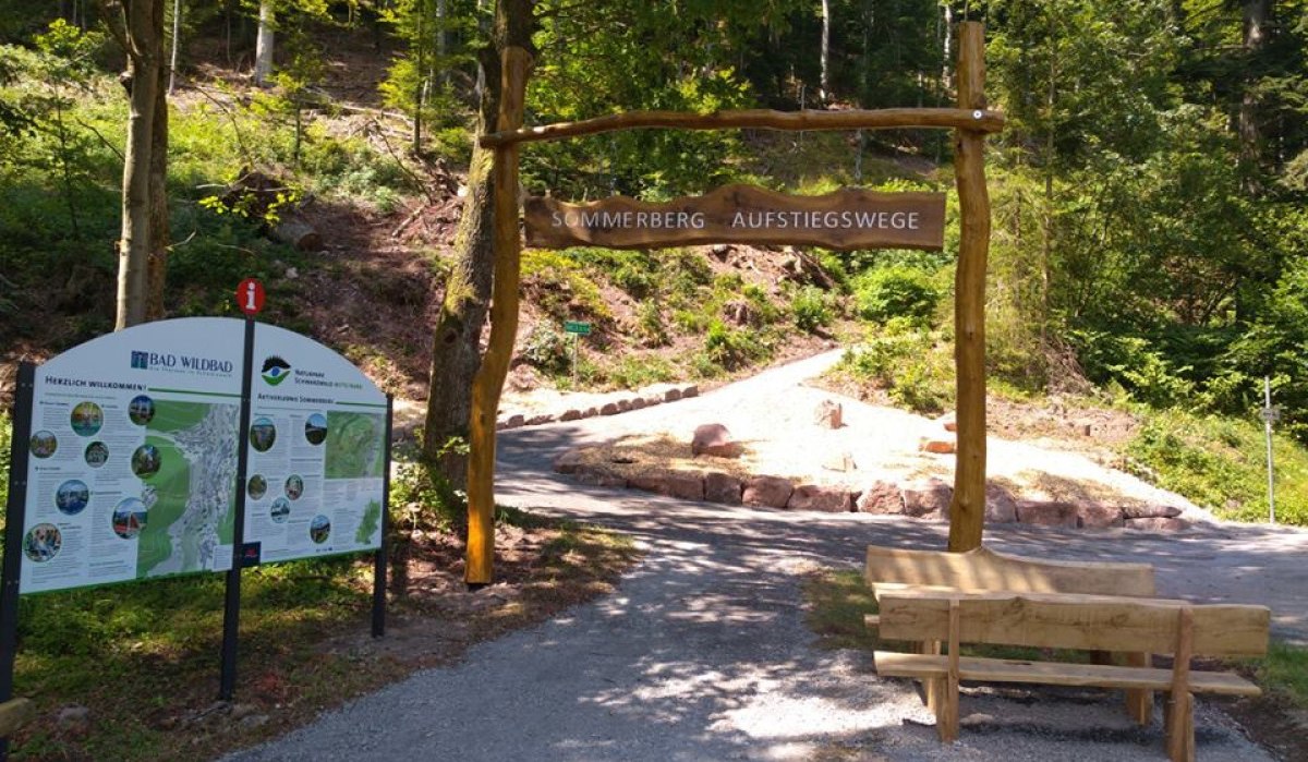 Holzportal mit Schild 'Sommerberg Aufstiegswege', Infotafel und Bank im Wald von Bad Wildbad., © Nördlicher Schwarzwald Holzportal mit Schild 'Sommerberg Aufstiegswege', Infotafel und Bank im Wald von Bad Wildbad., © Nördlicher Schwarzwald