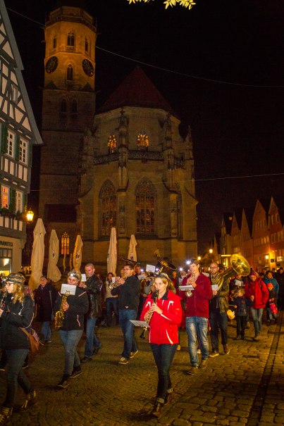 Menschen ziehen mit Blasinstrumenten bei Nacht durch Schorndorf. Im Hintergrund ist eine beleuchtete Kirche zu sehen., &copy; Stefanie Julia Heinrich