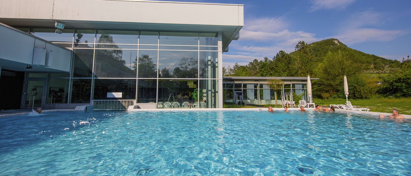 Die Vinzenz Therme in Bad Ditzenbach zeigt einen gro&szlig;en Au&szlig;enpool mit Menschen, die im Wasser entspannen. Im Hintergrund sind B&auml;ume und ein H&uuml;gel sichtbar., &copy; Stuttgart-Marketing GmbH, Achim Mende