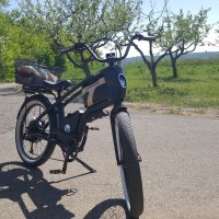 Ein schwarzes Youmo-E-Bike steht auf einer Straße in einer grünen, ländlichen Umgebung mit Bäumen im Hintergrund., © Hotel Weinstadt Ein schwarzes Youmo-E-Bike steht auf einer Straße in einer grünen, ländlichen Umgebung mit Bäumen im Hintergrund., © Hotel Weinstadt