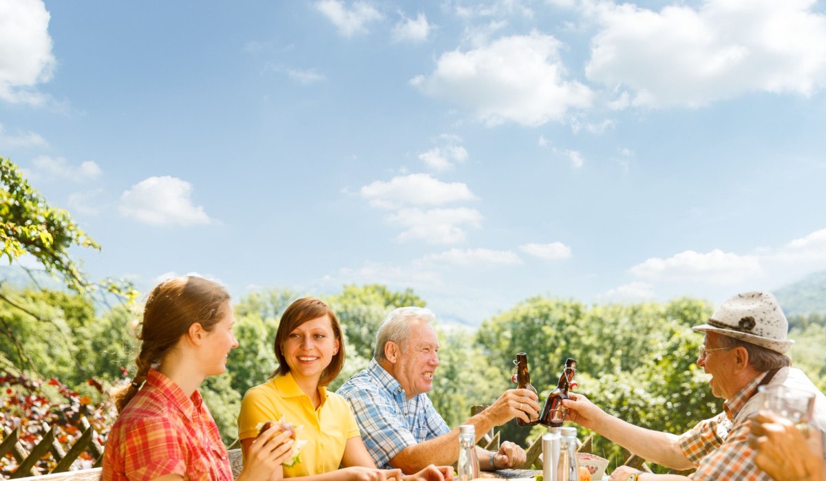 Menschen sitzen an einem Tisch im Freien, genießen ein Picknick bei sonnigem Wetter und stoßen mit Getränken an., © Landkreis Göppingen Menschen sitzen an einem Tisch im Freien, genießen ein Picknick bei sonnigem Wetter und stoßen mit Getränken an., © Landkreis Göppingen