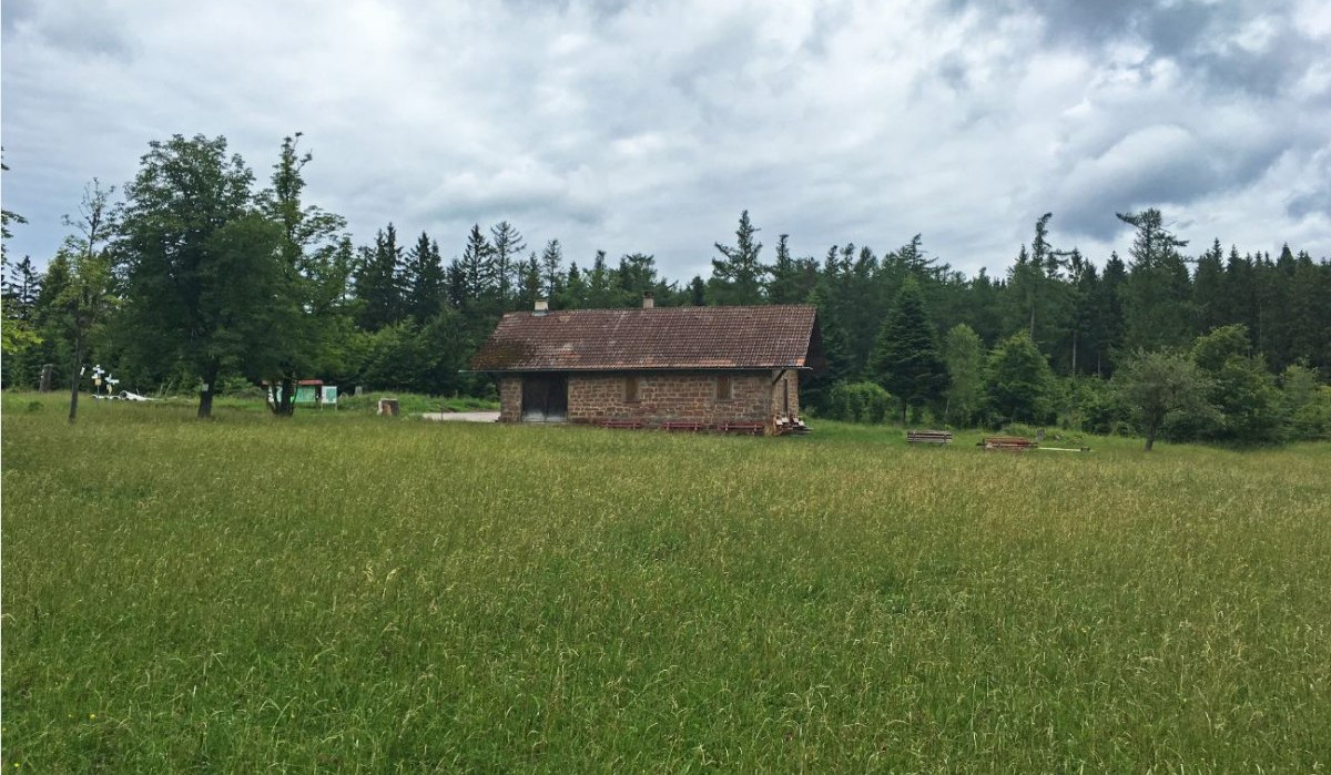 Kleine Hütte auf grüner Wiese, umgeben von Bäumen und bewölktem Himmel. Im Hintergrund dichter Wald., © www.pro-cycl.de Kleine Hütte auf grüner Wiese, umgeben von Bäumen und bewölktem Himmel. Im Hintergrund dichter Wald., © www.pro-cycl.de