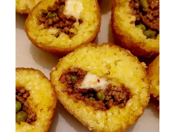 Gef&uuml;llte Reisb&auml;llchen mit Fleisch und Erbsen, goldbraun frittiert, aufgeschnitten und auf einem Teller angerichtet., &copy; Kultweine-Kochwelten-Kunst&uuml;cke - Kochschule Sonja Lenz