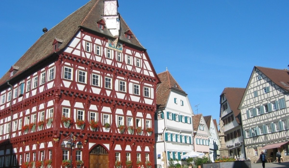 Fachwerkhäuser am Marktplatz in Markgröningen, darunter ein großes rotes Gebäude. Blauer Himmel und sonniges Wetter., © Aktiv-Region Stuttgart Fachwerkhäuser am Marktplatz in Markgröningen, darunter ein großes rotes Gebäude. Blauer Himmel und sonniges Wetter., © Aktiv-Region Stuttgart