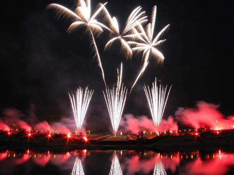 Ein spektakul&auml;res Feuerwerk mit wei&szlig;en und roten Effekten, das sich in einem Gew&auml;sser spiegelt. Der Nachthimmel ist hell erleuchtet., &copy; copyright: Marc Sansone