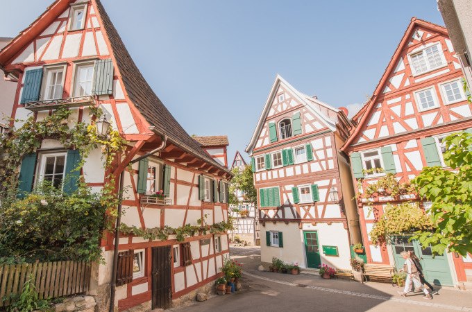 Fachwerkh&auml;user in Schorndorf mit roten Balken und gr&uuml;nen Fensterl&auml;den, umgeben von Pflanzen, unter blauem Himmel., &copy; Eigenbetrieb Tourismus und Citymanagement Schorndorf