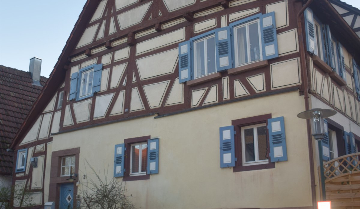 Fachwerkhaus mit blauen Fensterläden, geparktes Auto davor. Traditionelle Architektur, klare Himmel im Hintergrund., © Land der 1000 Hügel - Kraichgau-Stromberg Fachwerkhaus mit blauen Fensterläden, geparktes Auto davor. Traditionelle Architektur, klare Himmel im Hintergrund., © Land der 1000 Hügel - Kraichgau-Stromberg