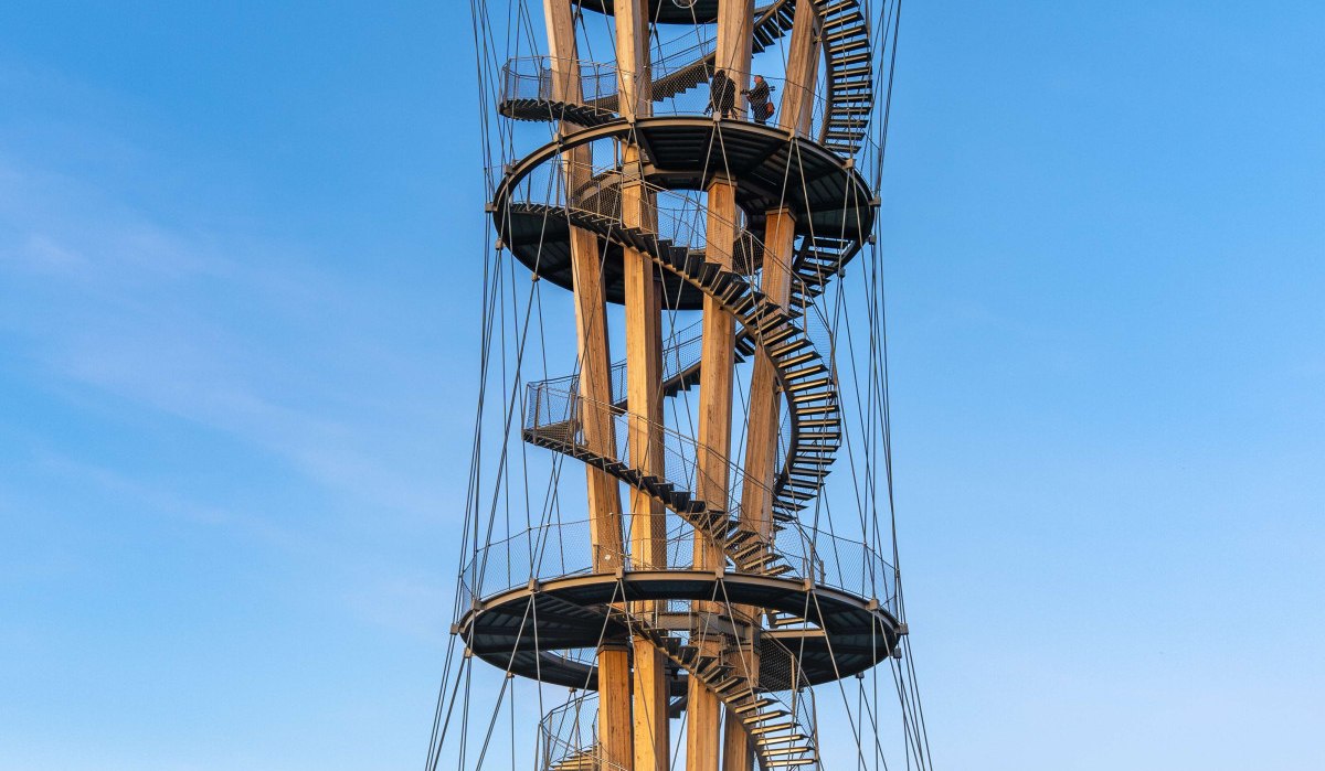 Aussichtsturm mit spiralförmiger Treppe, umgeben von Radfahrern und Bäumen, vor blauem Himmel., © Stuttgart Marketing GmbH Martina Denker Aussichtsturm mit spiralförmiger Treppe, umgeben von Radfahrern und Bäumen, vor blauem Himmel., © Stuttgart Marketing GmbH Martina Denker