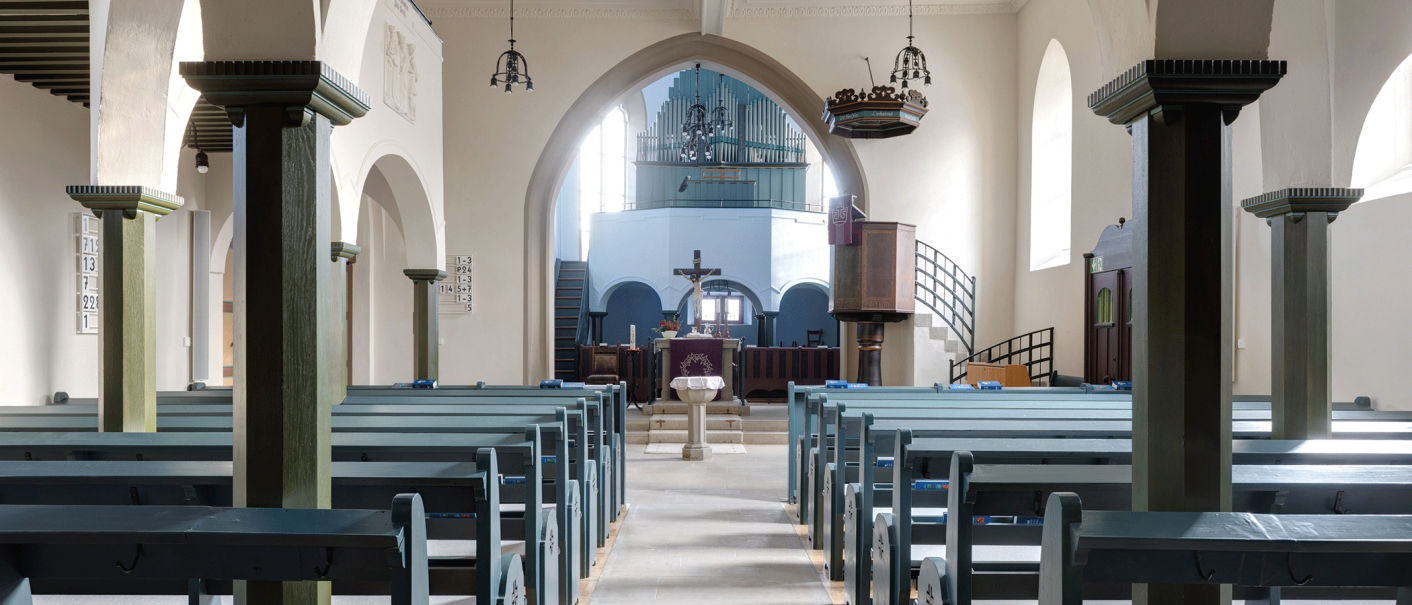 Innenansicht der Kirche mit blauen Bänken, Altar, Kanzel und Orgel im Hintergrund. Helle Wände und große Bögen prägen den Raum., © Stadt Gaildorf Innenansicht der Kirche mit blauen Bänken, Altar, Kanzel und Orgel im Hintergrund. Helle Wände und große Bögen prägen den Raum., © Stadt Gaildorf