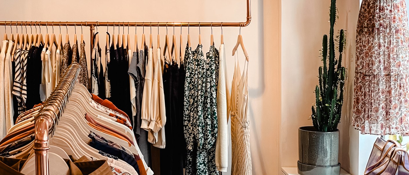 Modegeschäft mit Kleiderstange voller Kleidung, Kaktus in der Ecke und Schaufensterpuppe im Fenster. Elegante Beleuchtung von oben., © MAGASIN Geißstrasse 15, Stuttgart Modegeschäft mit Kleiderstange voller Kleidung, Kaktus in der Ecke und Schaufensterpuppe im Fenster. Elegante Beleuchtung von oben., © MAGASIN Geißstrasse 15, Stuttgart