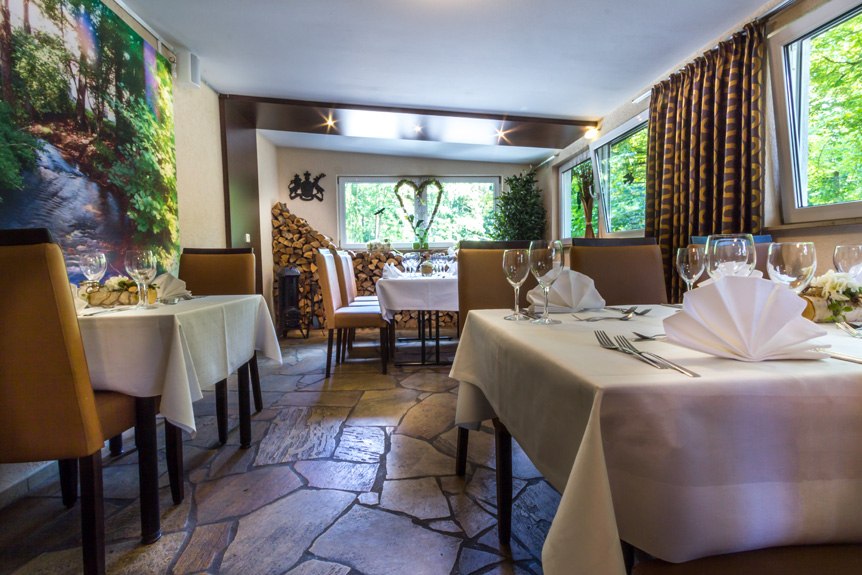 Eleganter Frühstücksraum mit gedeckten Tischen, weißen Tischdecken und großen Fenstern mit Blick ins Grüne., © Kulinarium an der Glems