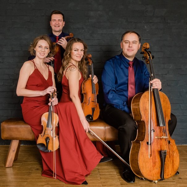 Ein Streichquartett in eleganter Kleidung posiert mit ihren Instrumenten vor einer dunklen Wand. Zwei Frauen tragen rote Kleider, die M&auml;nner Hemden mit Krawatten., &copy; Mercedes-Benz AG