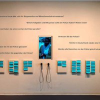 Ausstellungswand mit Fragen zur Polizei und Bürgerrechten, Notizen und Kopfhörern. Besucher können ihre Gedanken aufschreiben und anhören., © Haus der Geschichte Baden-Württemberg