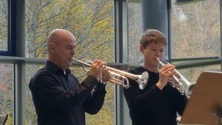 Zwei Trompeter spielen vor einem Notenständer in einem lichtdurchfluteten Raum mit großen Fenstern., © Musikschule Bad Urach Zwei Trompeter spielen vor einem Notenständer in einem lichtdurchfluteten Raum mit großen Fenstern., © Musikschule Bad Urach
