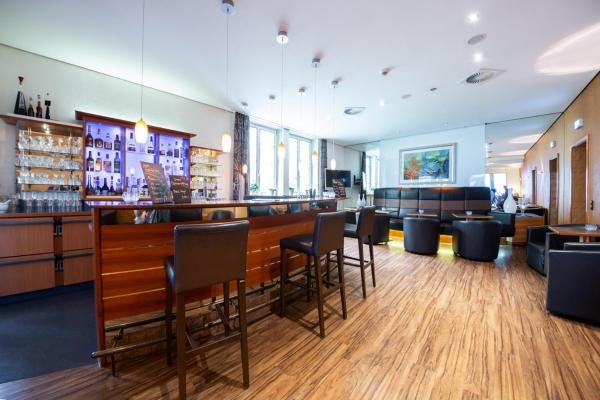 Moderne Hotelbar mit Holzboden, Barhockern und gemütlichem Sitzbereich. Die Bar ist gut beleuchtet und stilvoll eingerichtet., © Kronen Hotel GmbH