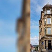 Historisches Eckgeb&auml;ude mit Apotheke im Erdgeschoss, umgeben von Stra&szlig;en und Autos, unter blauem Himmel., &copy; SMG