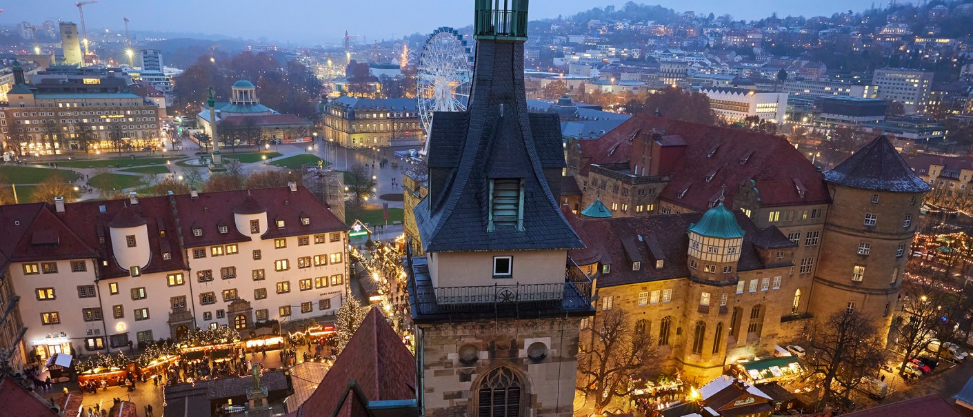 Blick auf den Schillerplatz und das Alte Schloss in Stuttgart bei Dämmerung. Der Weihnachtsmarkt ist beleuchtet, im Hintergrund ein Riesenrad., © Stuttgart Marketing GmbH