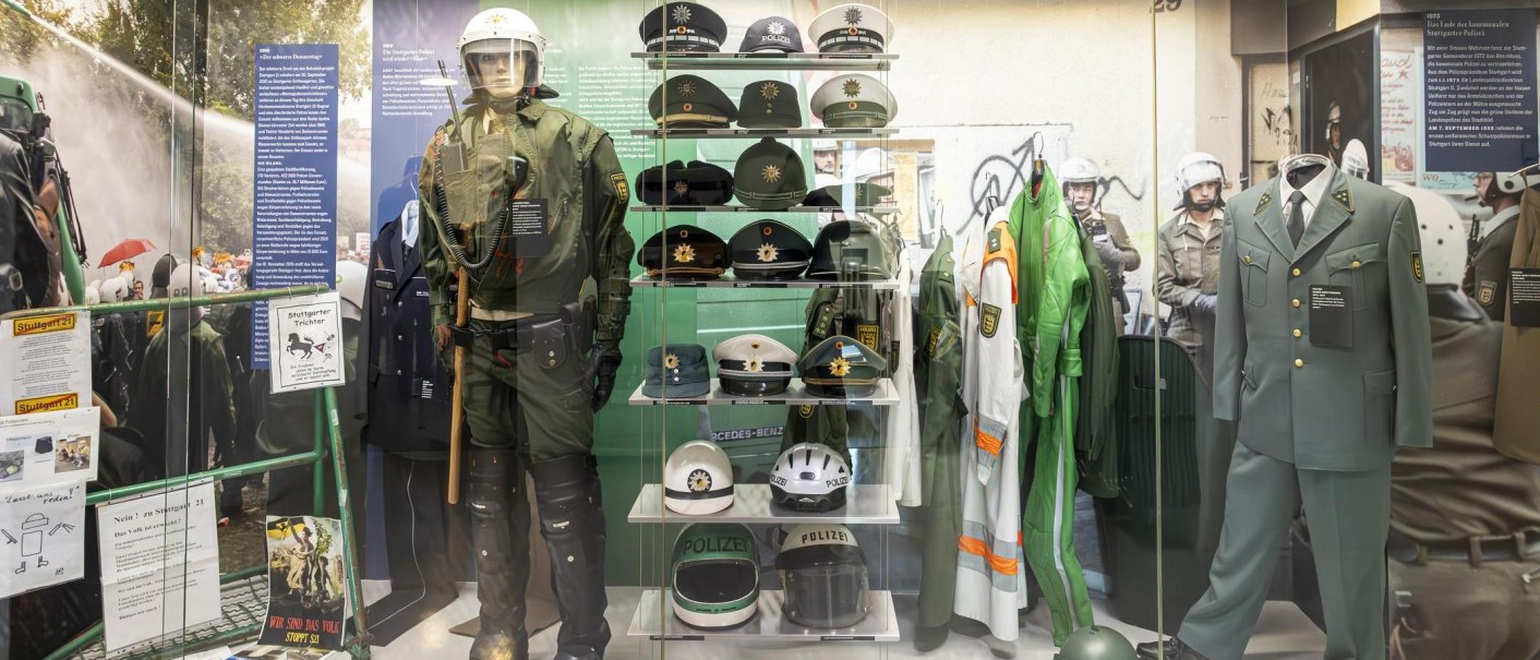 Ausstellung im Polizeimuseum Stuttgart mit verschiedenen Polizeiuniformen, Helmen und Ausrüstungsgegenständen in einer Vitrine., © Stuttgart-Marketing GmbH, Sarah Schmid