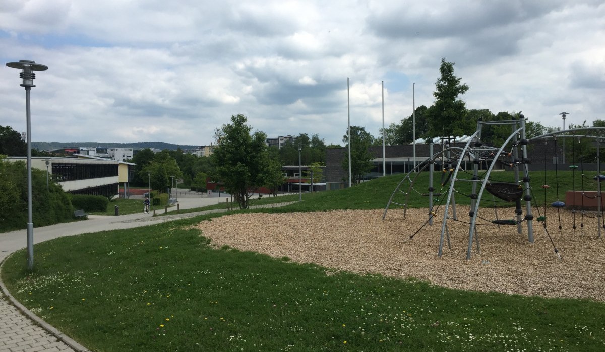 Spielplatz in Herrenberg mit Klettergerüst, umgeben von Grünflächen und Gehwegen. Im Hintergrund sind Gebäude und Bäume zu sehen., © Natur.Nah. Schönbuch & Heckengäu Spielplatz in Herrenberg mit Klettergerüst, umgeben von Grünflächen und Gehwegen. Im Hintergrund sind Gebäude und Bäume zu sehen., © Natur.Nah. Schönbuch & Heckengäu