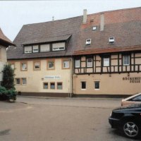 Fachwerkhaus mit Bäckerei Jülle und Gästehaus Löckle in Remseck-Neckargröningen. Vor dem Gebäude stehen Autos und Pflanzen., © Gästehaus Löckle