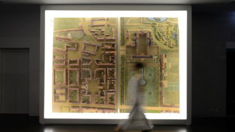 Eine Person bewegt sich vor einem beleuchteten Stadtplan im Museumsfoyer. Die Karte zeigt detaillierte Geb&auml;ude und Gr&uuml;nfl&auml;chen., &copy; Ludwigsburg Museum