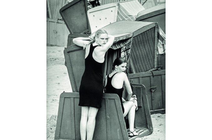 Zwei Frauen in Badeanzügen posieren in und neben Strandkörben an einem Sandstrand. Die Szene wirkt nostalgisch und sommerlich., © Kunsthalle Göppingen Zwei Frauen in Badeanzügen posieren in und neben Strandkörben an einem Sandstrand. Die Szene wirkt nostalgisch und sommerlich., © Kunsthalle Göppingen