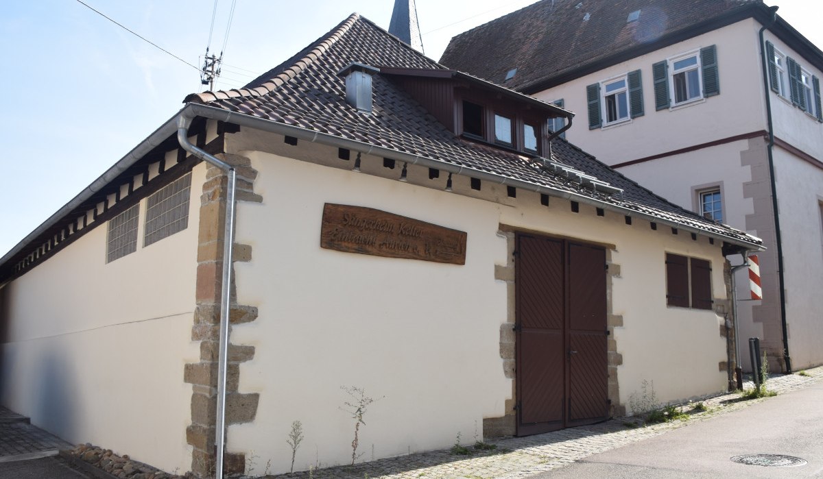 Traditionelles Gebäude mit Schild "Sängerheim Keller", braune Türen und Fensterläden, in einer Dorfstraße. Historische Architektur mit Ziegeldach., © Land der 1000 Hügel - Kraichgau-Stromberg Traditionelles Gebäude mit Schild "Sängerheim Keller", braune Türen und Fensterläden, in einer Dorfstraße. Historische Architektur mit Ziegeldach., © Land der 1000 Hügel - Kraichgau-Stromberg