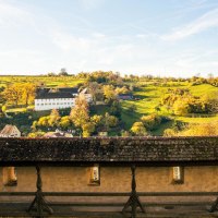 Blick von der Großcomburg auf eine malerische Landschaft mit einem weißen Gebäude und herbstlichen Bäumen im Hintergrund., © Stuttgart-Marketing GmbH, Sarah Schmid