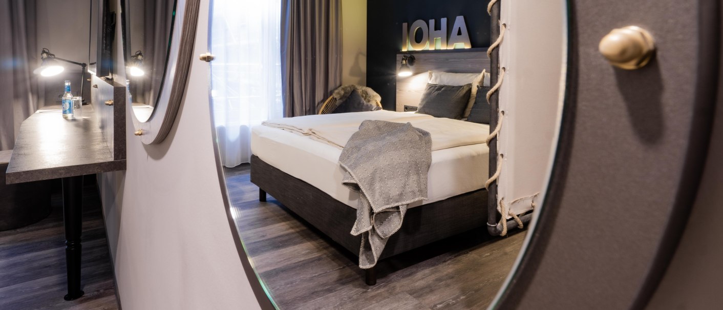 Modernes Hotelzimmer mit Doppelbett, Spiegel und Schreibtisch. Der Raum ist stilvoll dekoriert mit neutralen Farben und einem großen Fenster., © HARBR. hotel Ludwigsburg / DQuadrat Living GmbH Modernes Hotelzimmer mit Doppelbett, Spiegel und Schreibtisch. Der Raum ist stilvoll dekoriert mit neutralen Farben und einem großen Fenster., © HARBR. hotel Ludwigsburg / DQuadrat Living GmbH