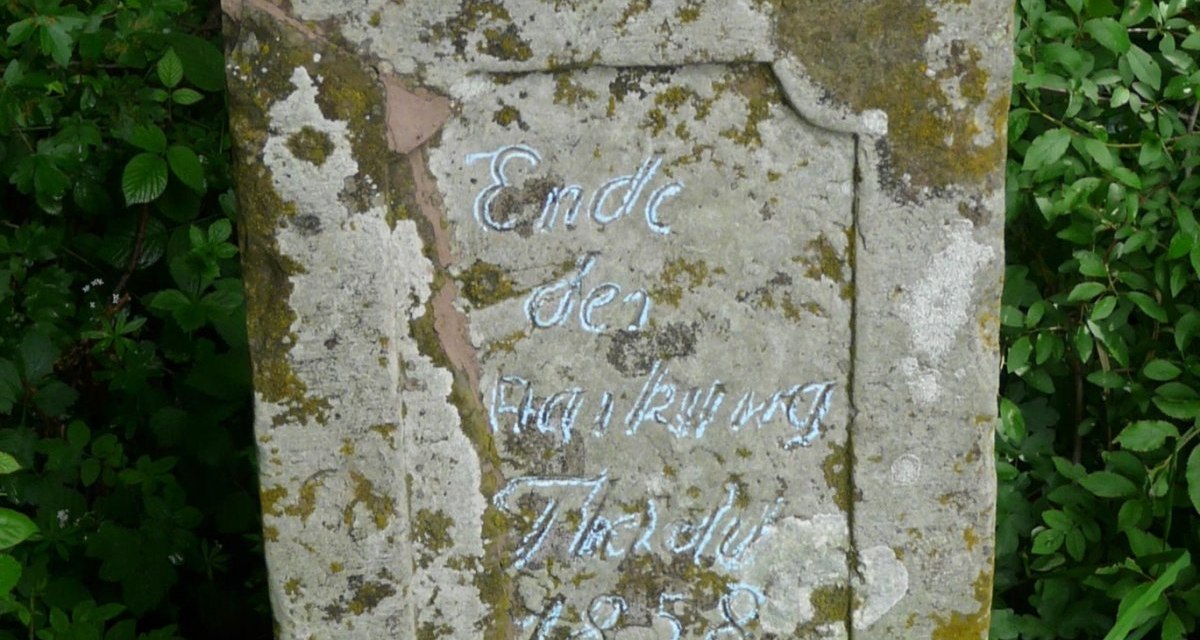 Ein verwitterter Grenzstein mit der Inschrift 'Ende des ... Thale 1858', umgeben von üppigem Grün., © Natur.Nah. Schönbuch & Heckengäu Ein verwitterter Grenzstein mit der Inschrift 'Ende des ... Thale 1858', umgeben von üppigem Grün., © Natur.Nah. Schönbuch & Heckengäu