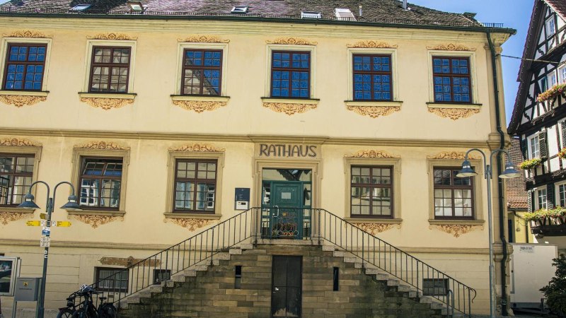 Das historische Rathaus von Vaihingen an der Enz mit Treppe und verzierten Fenstern, daneben ein Fachwerkhaus mit Blumenkästen., © Stuttgart-Marketing GmbH, Sarah Schmid