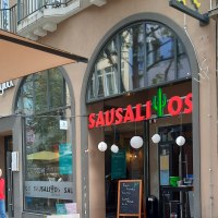 Eingang des Restaurants Sausalitos mit rotem Schriftzug und Kaktus-Logo. Ein Schild bewirbt Taco Tuesday. Außenbereich mit Holztischen., © SMG Eingang des Restaurants Sausalitos mit rotem Schriftzug und Kaktus-Logo. Ein Schild bewirbt Taco Tuesday. Außenbereich mit Holztischen., © SMG