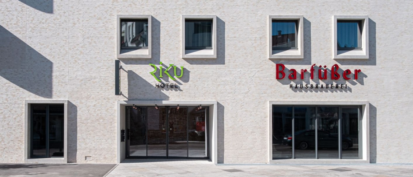 Moderne Fassade mit Schildern von Riku Hotel und Barfüßer Hausbrauerei, helle Ziegelsteine, große Fenster., © 13 6 Design GmbH (Judenhof 10, 89073 Ulm) Moderne Fassade mit Schildern von Riku Hotel und Barfüßer Hausbrauerei, helle Ziegelsteine, große Fenster., © 13 6 Design GmbH (Judenhof 10, 89073 Ulm)