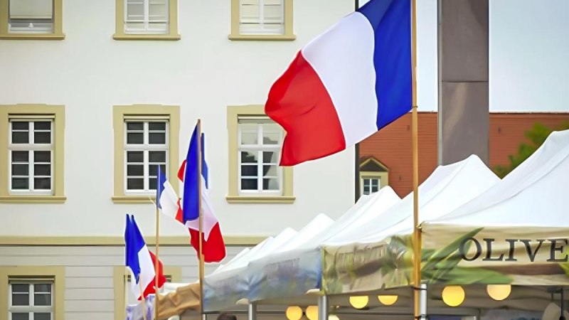 Französische Flaggen wehen über Marktständen auf einem Platz. Im Hintergrund ist ein Gebäude mit mehreren Fenstern zu sehen., © Ludwigsburg Französische Flaggen wehen über Marktständen auf einem Platz. Im Hintergrund ist ein Gebäude mit mehreren Fenstern zu sehen., © Ludwigsburg