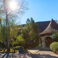 Das Carl Schweizer Museum in Murrhardt bei strahlendem Sonnenschein, umgeben von Bäumen und Pflanzen. Der Eingang hat ein rundes Dach., © Stuttgart-Marketing GmbH, Achim Mende