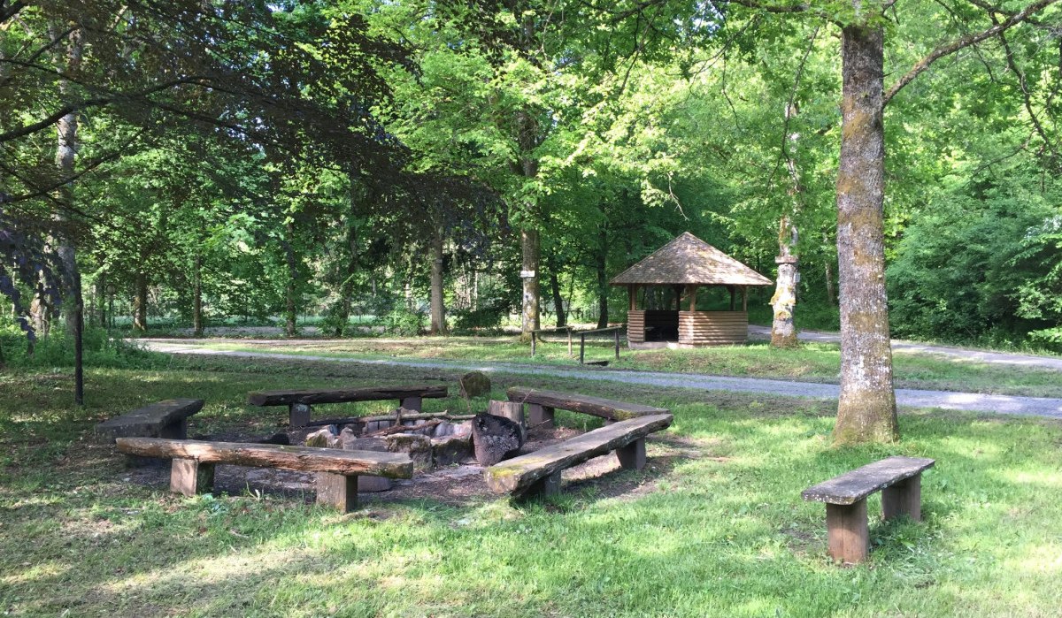 Ein idyllischer Grillplatz im Wald mit Holzbänken um eine Feuerstelle. Im Hintergrund steht ein kleiner Pavillon., © www.pro-cycl.de Ein idyllischer Grillplatz im Wald mit Holzbänken um eine Feuerstelle. Im Hintergrund steht ein kleiner Pavillon., © www.pro-cycl.de