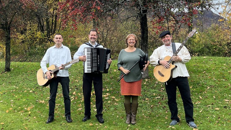 Vier Musiker posieren auf einer Wiese vor herbstlichen B&auml;umen. Zwei halten Gitarren, einer ein Akkordeon und eine Frau eine Fl&ouml;te. Sie l&auml;cheln in die Kamera., &copy; (c) The Craic
