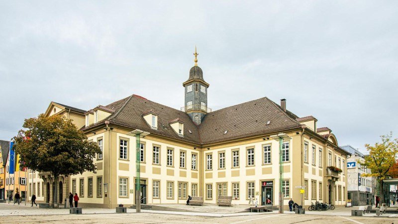Das Rathaus von G&ouml;ppingen auf dem Marktplatz, umgeben von B&auml;umen und Menschen. Der Uhrturm ragt in den bew&ouml;lkten Himmel., &copy; Stuttgart-Marketing GmbH, Sarah Schmid