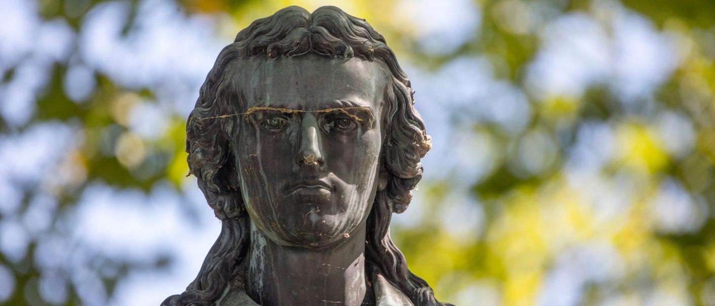 Nahaufnahme des Schillerdenkmals in Marbach am Neckar, mit unscharfem Laub im Hintergrund., © SMG Achim Mende Nahaufnahme des Schillerdenkmals in Marbach am Neckar, mit unscharfem Laub im Hintergrund., © SMG Achim Mende