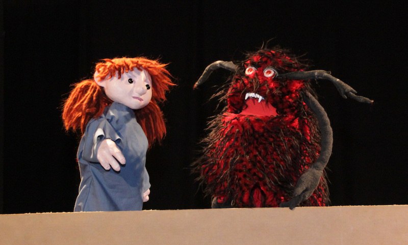 Zwei Puppen auf einer Bühne: eine mit roten Haaren und blauer Kleidung, die andere ein zotteliges, rotes Monster mit Hörnern., © FILharmonie Filderstadt Zwei Puppen auf einer Bühne: eine mit roten Haaren und blauer Kleidung, die andere ein zotteliges, rotes Monster mit Hörnern., © FILharmonie Filderstadt