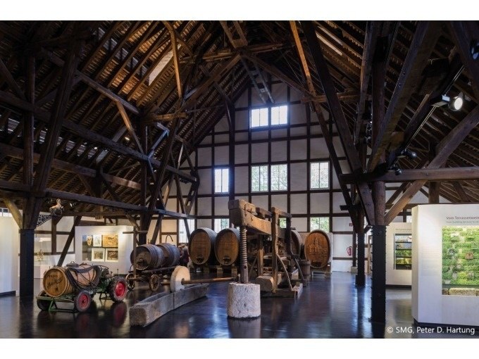 Innenansicht eines Weinbaumuseums mit gro&szlig;en Holzf&auml;ssern und rustikalen Holzbalken. Historische Weinpressen und Ausstellungsst&uuml;cke sind zu sehen., &copy; Stuttgart Marketing GmbH
