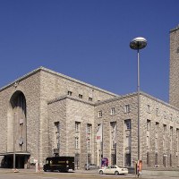 Der Hauptbahnhof Stuttgart mit seinem markanten Uhrturm und Mercedes-Stern, umgeben von Autos und B&auml;umen, unter einem klaren blauen Himmel., &copy; Stuttgart-Marketing GmbH